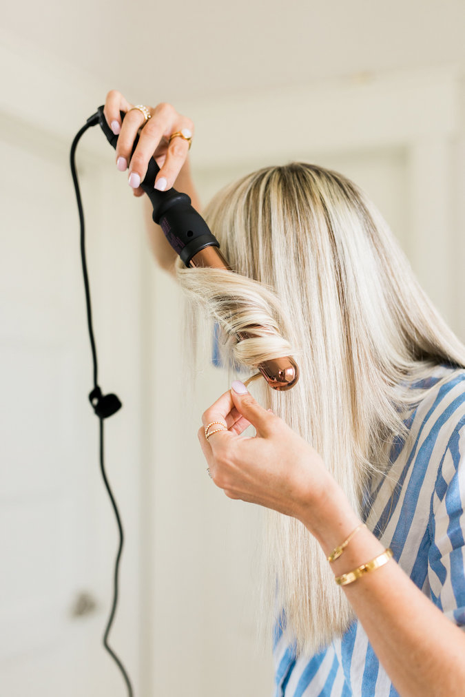 How to Curl Long Hair FAST & Keep your Hair Healthy featured by top Utah beauty blog, A Slice of Style: image of a woman holding a curling wand