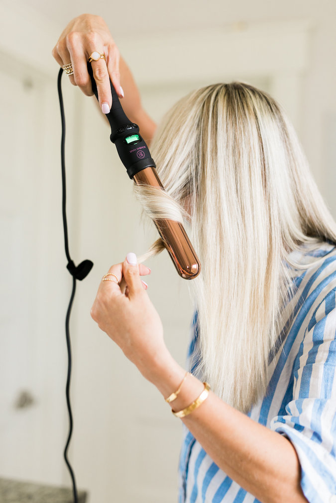 How to Curl Long Hair FAST & Keep your Hair Healthy featured by top Utah beauty blog, A Slice of Style: image of a woman holding a curling wand