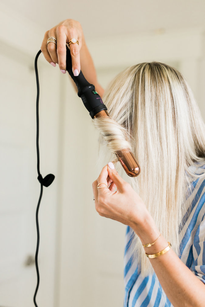 How to Curl Long Hair FAST & Keep your Hair Healthy featured by top Utah beauty blog, A Slice of Style: image of a woman holding a curling wand