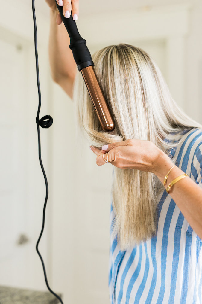 How to Curl Long Hair FAST & Keep your Hair Healthy featured by top Utah beauty blog, A Slice of Style: image of a woman holding a curling wand