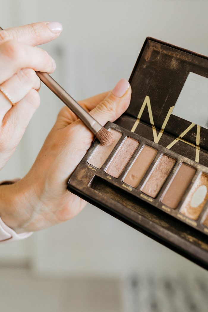 NAKED Palette Tutorial featured by top US beauty blog A Slice of Style; Image of woman in mustard sweater, applying eye shadow.