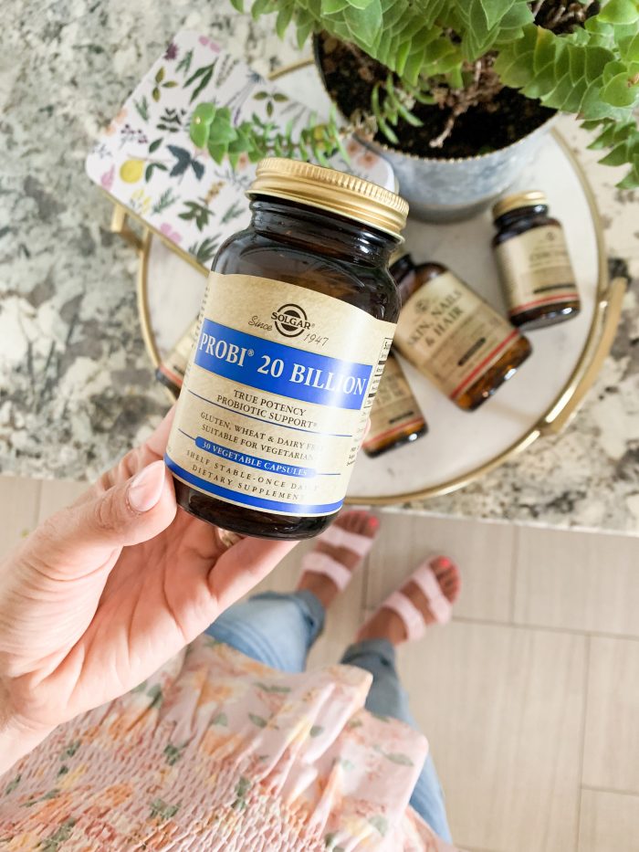 Solgar Vitamins Review + Green Smoothie Recipe by popular Utah life and style blog, A Slice of Style: image of a woman holding a bottle of Solgar Vitamins Probi 20 Billion.