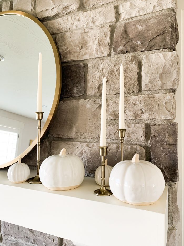 My Home Decorated for Fall! by popular Utah lifestyle blog, A Slice of Style: image of a fireplace mantle decorated with Target Threshold cream Decorative Ceramic Pumpkins, Target Threshold Plaid Cotton Throw Blanket, Target Threshold Cable Knit Chenille Throw Pillow, and Etsy Crateful Studio Chunky Knit Blanket.