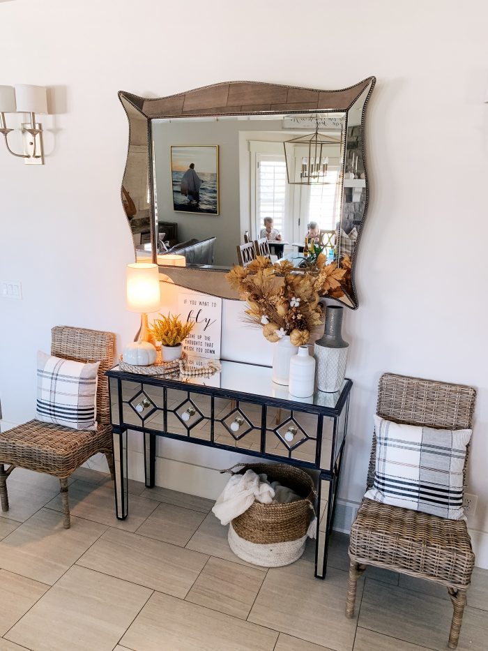 My Home Decorated for Fall! by popular Utah lifestyle blog, A Slice of Style: image of a entry table decorated with white Home Depot Three Hands ceramic vases, a Threshold 11" x 10" Artificial Goldenrod Arrangement in Ceramic Pot from Target and a Home Depot LR Resources Natural Jute Decorative Storage Basket underneath with some neutral blankets in it.