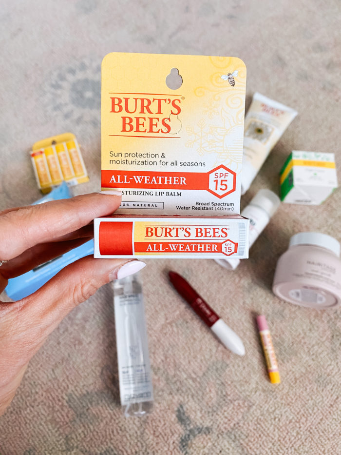 Walmart Beauty Products by popular Utah beauty blog, A Slice of Style: image of a woman holding a Walmart Burt's Bees All-Weather lip balm. 