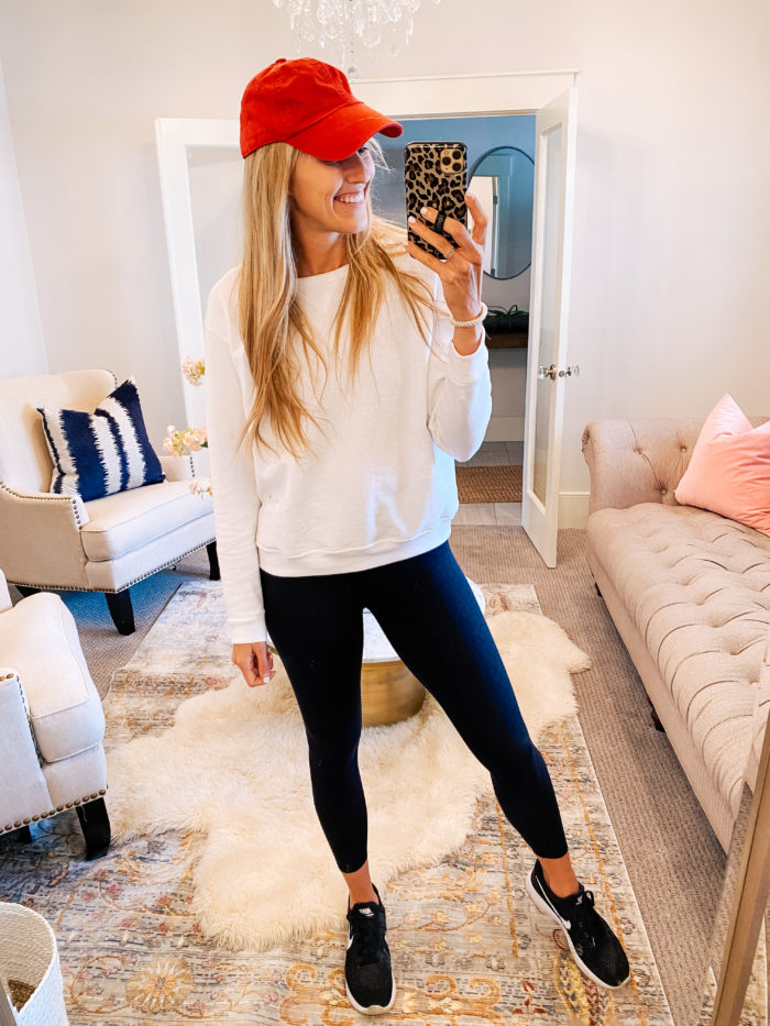 Amazon haul by popular Utah fashion blog, A Slice of Style: image of a woman wearing a Amazon Hanes Women's V-Notch Pullover Fleece Sweatshirt, red ball cap, blue leggings, and block nike sneakers. 