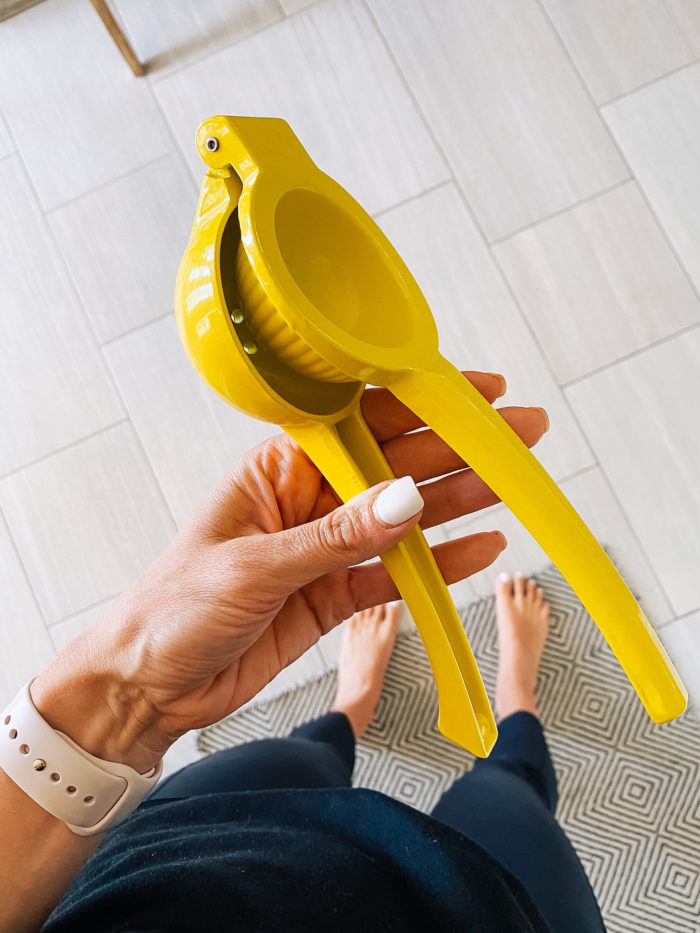Best Kitchen Tools by popular Utah lifestyle blog, A Slice of Style: image of Jenica Parcell holding a yellow lemon squeezer. 
