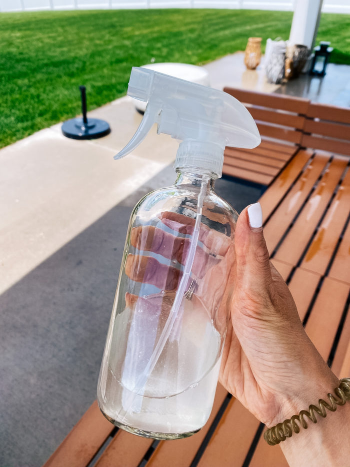 White Outdoor Cushions by popular Utah life and style blog, A Slice of Style: image of Jenica Parcell holding a glass spray bottle. 