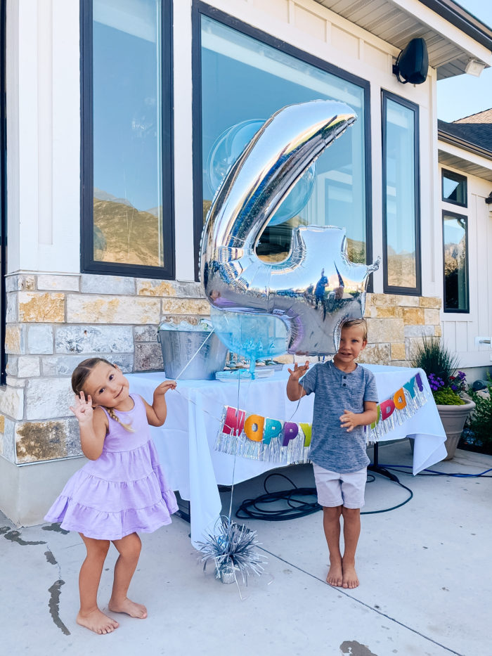 4th Birthday Party by popular Utah motherhood blog, A Slice of Style: image of boy and girl twins holding a birthday balloon bouquet together. 