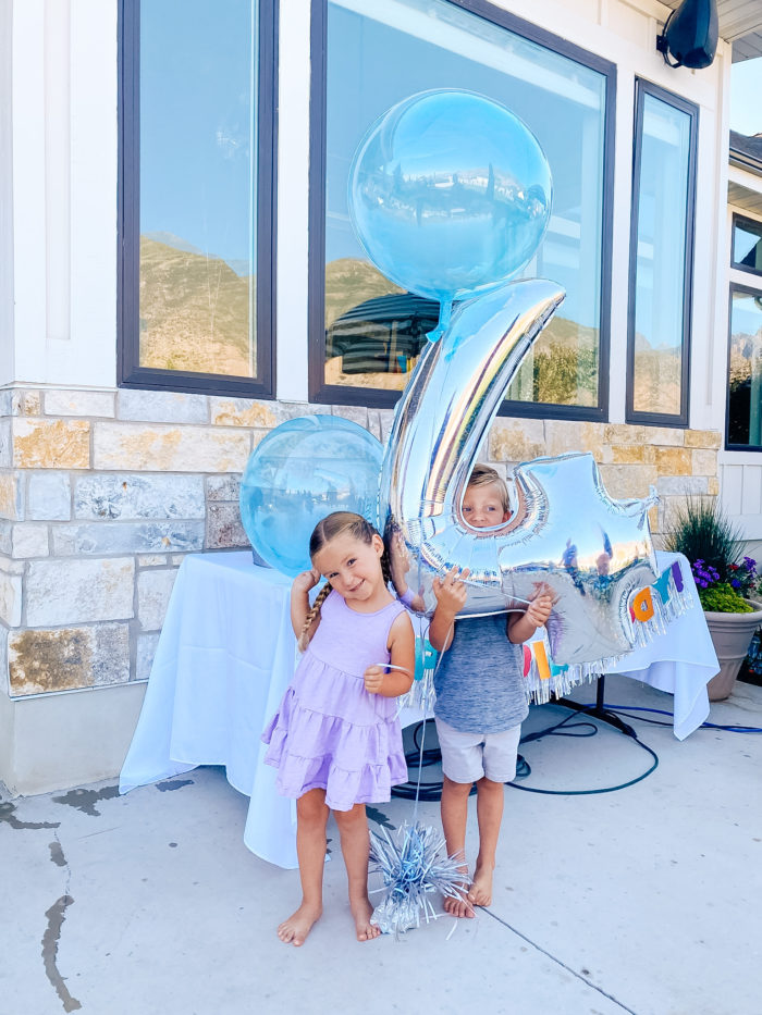 4th Birthday Party by popular Utah motherhood blog, A Slice of Style: image of boy and girl twins holding a birthday balloon bouquet together. 