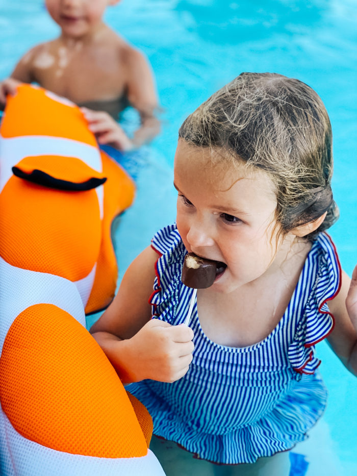 4th Birthday Party by popular Utah motherhood blog, A Slice of Style: image of a little girl eating a frozen chocolate covered banana. 